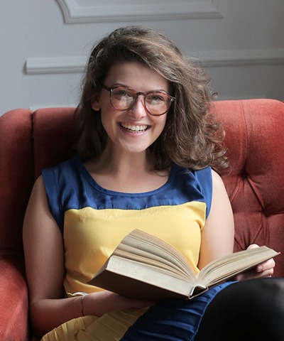 woman in blue and yellow dress sitting on red sofa.jpg
