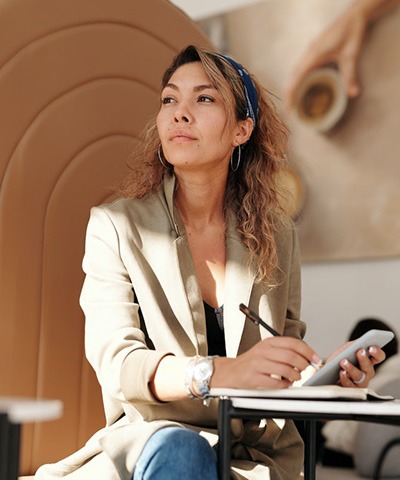 woman wearing blazer and blue denim jeans sitting on chair.jpg